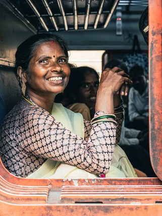 Indian woman smiling from a train